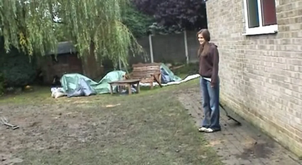 Judith stands near the backyard shed while filming her family in Exhibit A 2007