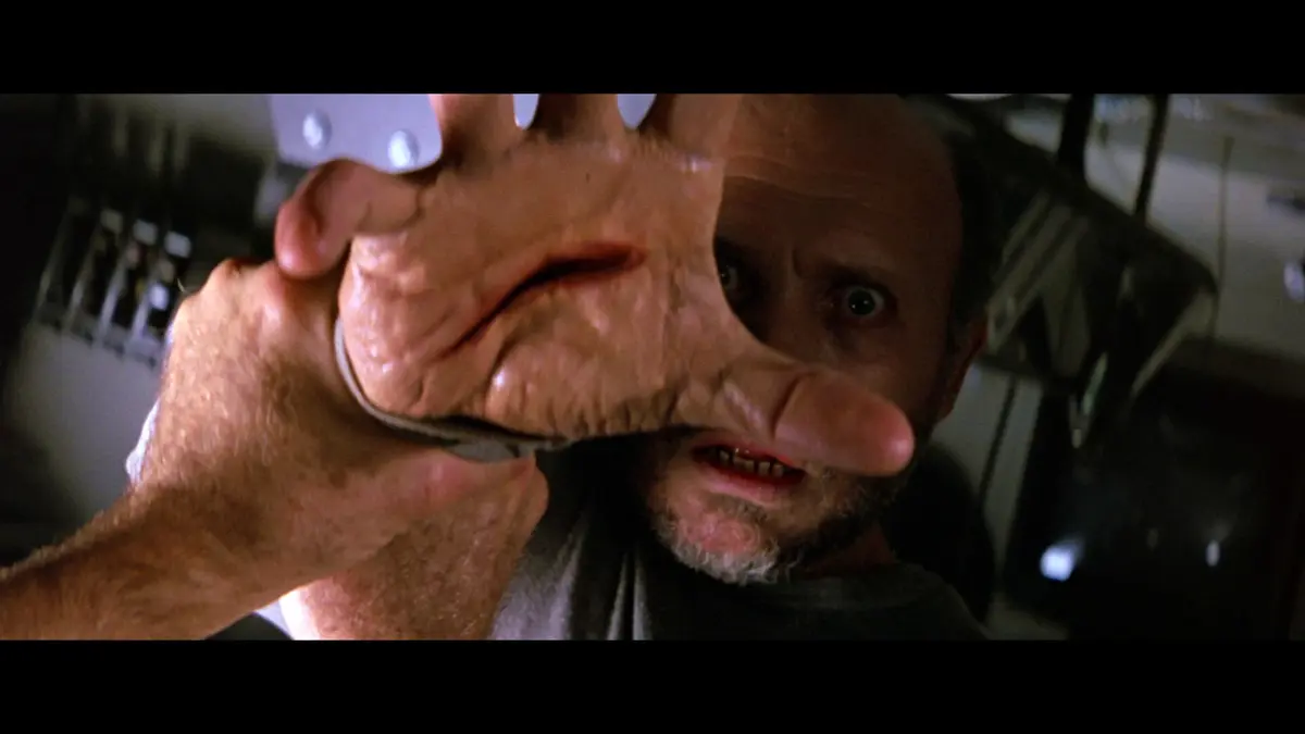 A grotesque hand mutation appears on a crew member in Leviathan 1989