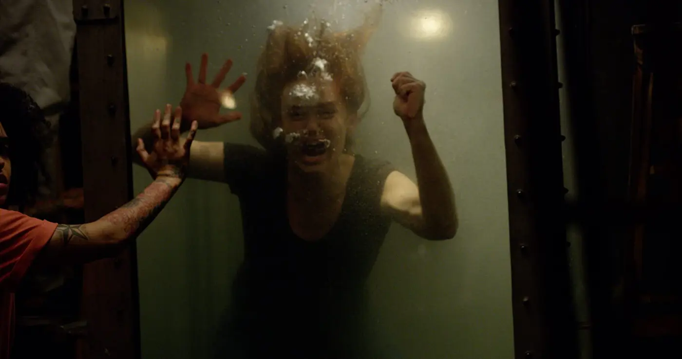 Erin struggles underwater inside the escape-room tank in No Escape 2020