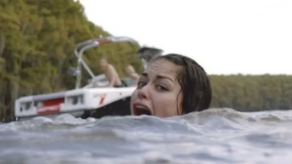 Maya struggles in the lake during a shark attack in Shark Night 2011