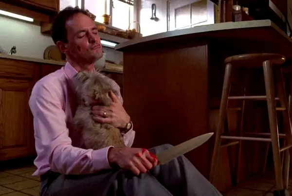 A bloodied Jerry holds the family dog and a knife in The Stepfather 1987