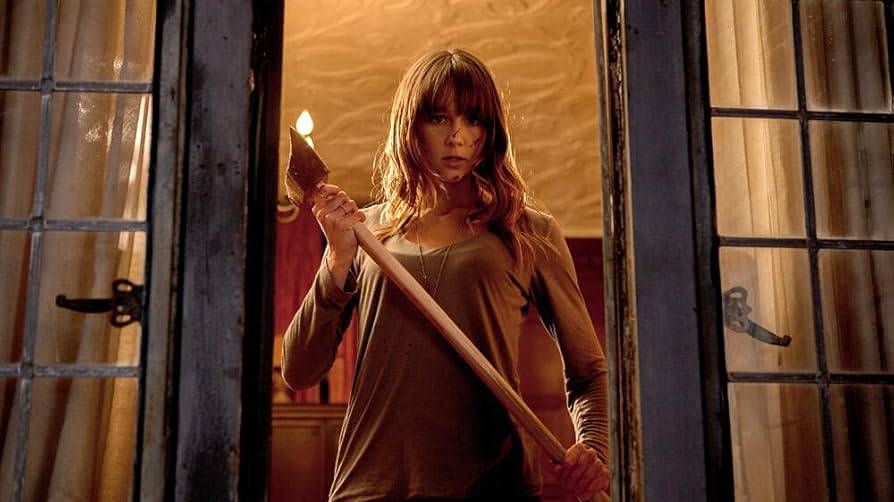 Erin holding an axe inside the Davison house